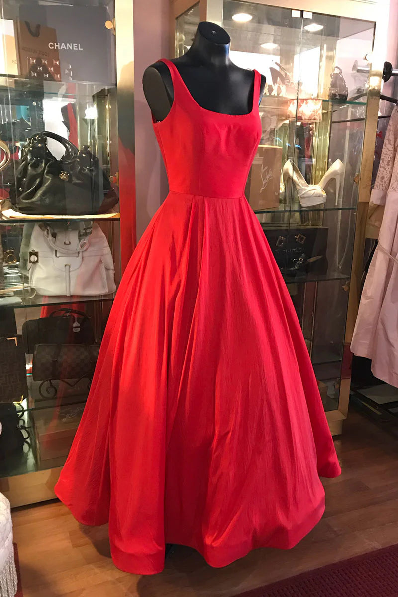 Model wearing an elegant red tea-length prom dress with a V-neck and cinched waist.