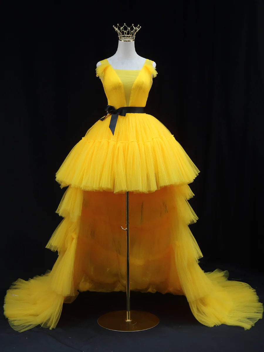 Front view of a woman wearing an elegant yellow tulle V-neck A-line prom dress with a cinched waist.