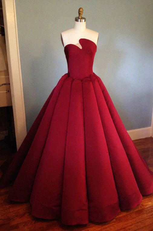 Woman wearing a long burgundy satin prom dress, front view.