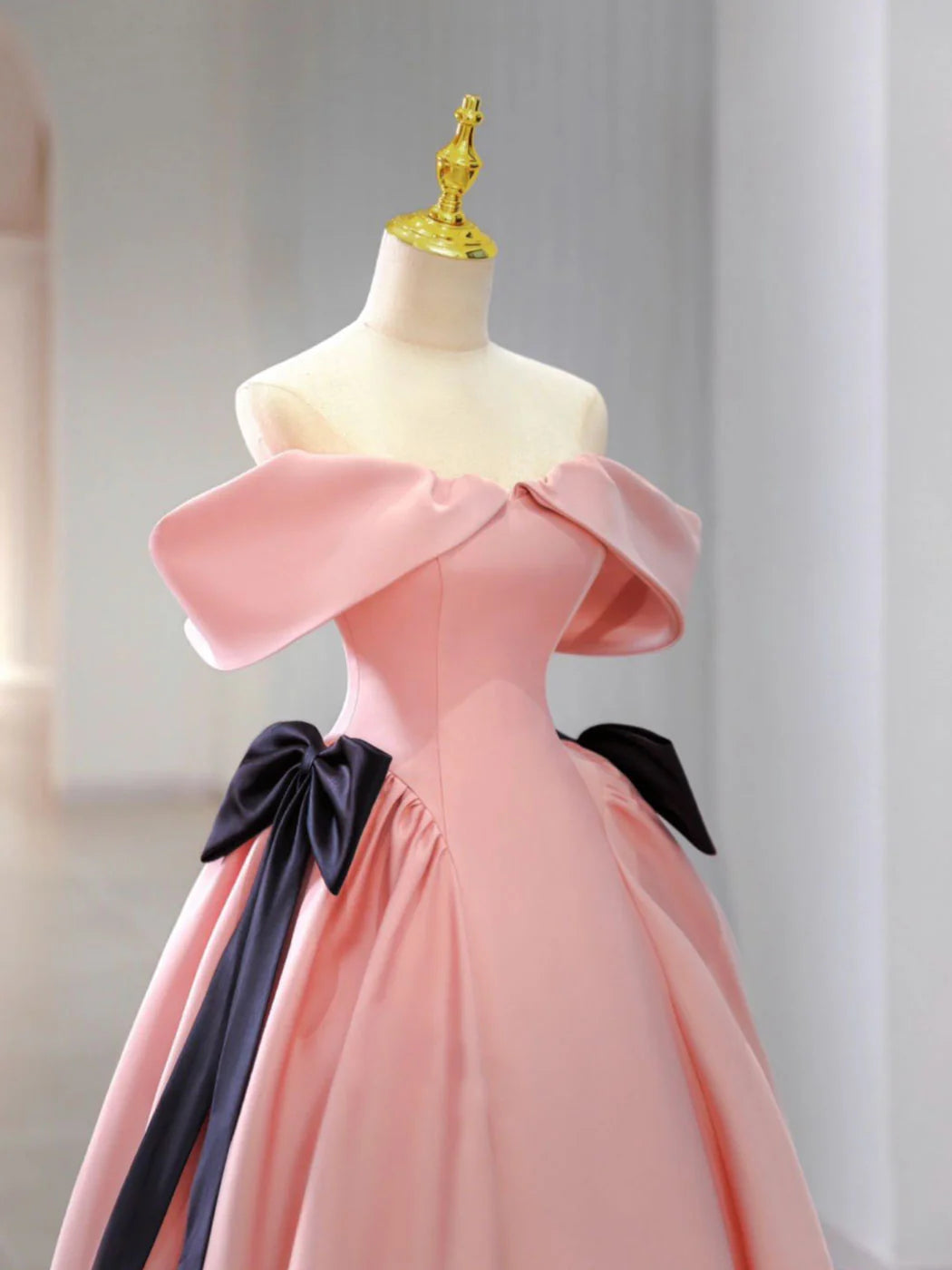Side view of a woman in a pink satin long evening gown, showcasing the A-line silhouette.