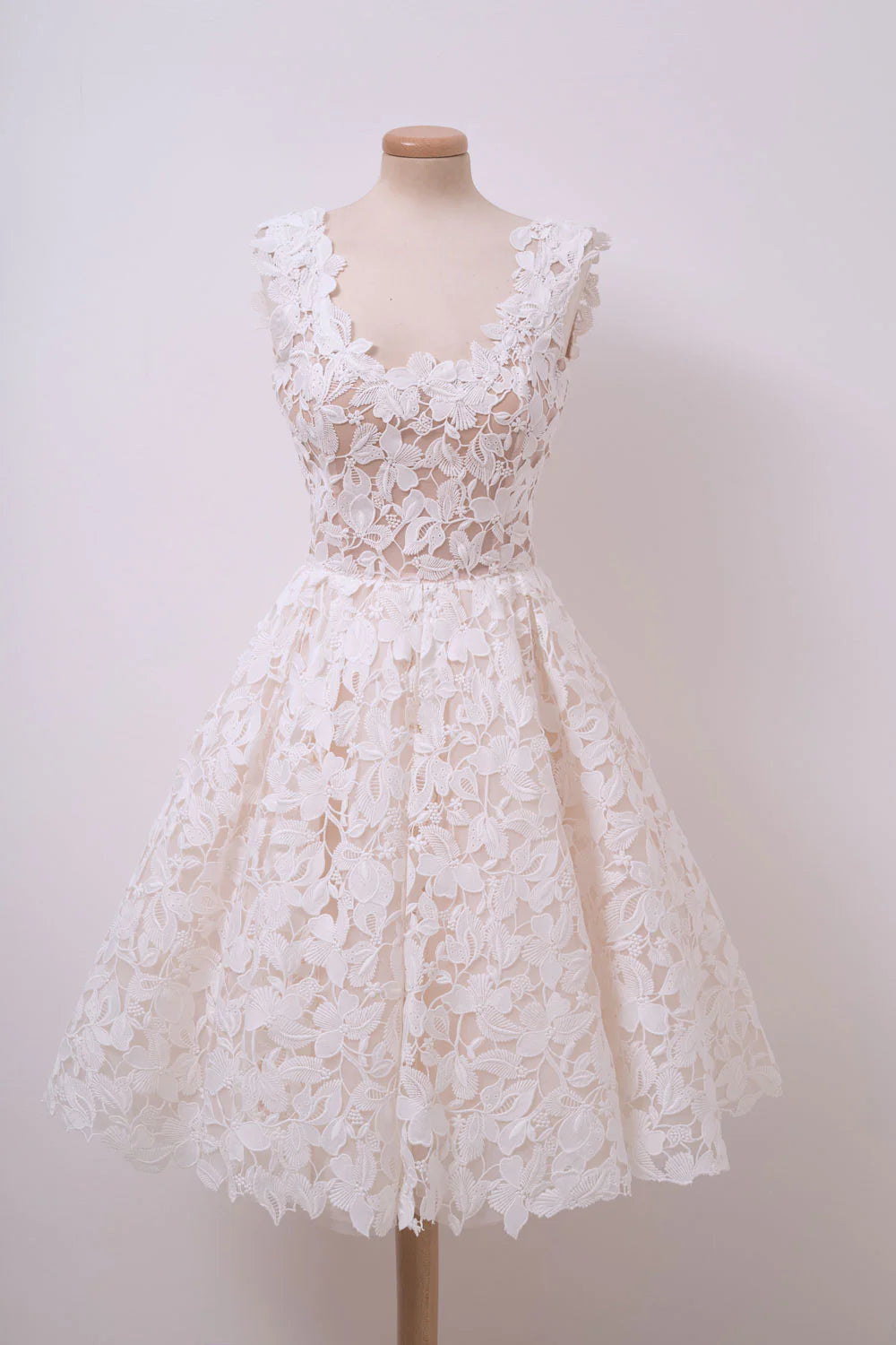 Model in an elegant ivory white lace short prom dress.