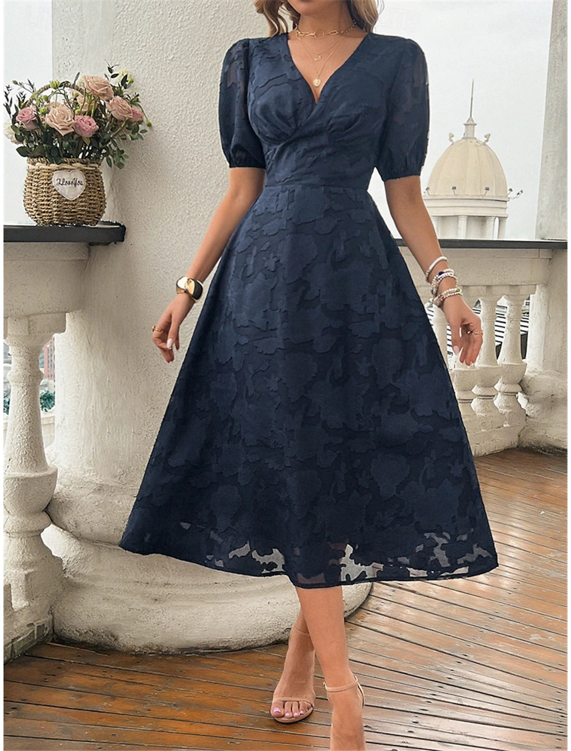 Woman wearing an elegant A-line V-neck sleeveless lace patchwork midi dress, front view.