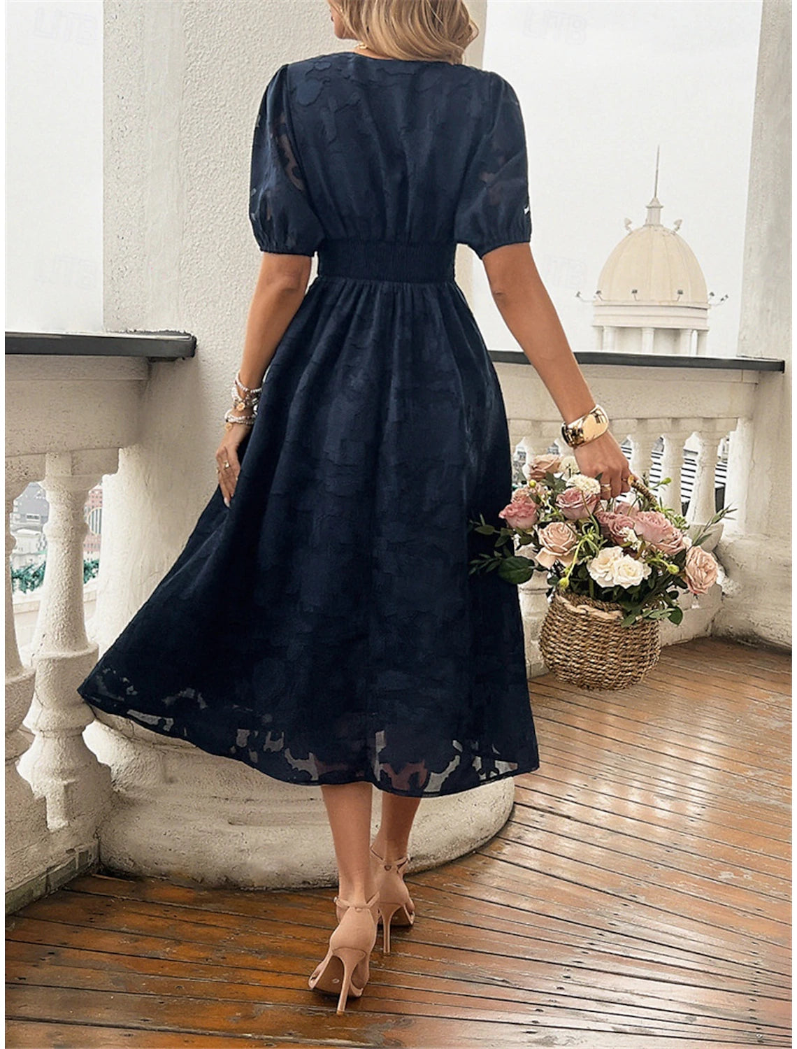 Woman wearing an elegant A-line V-neck sleeveless lace patchwork midi dress, side view.