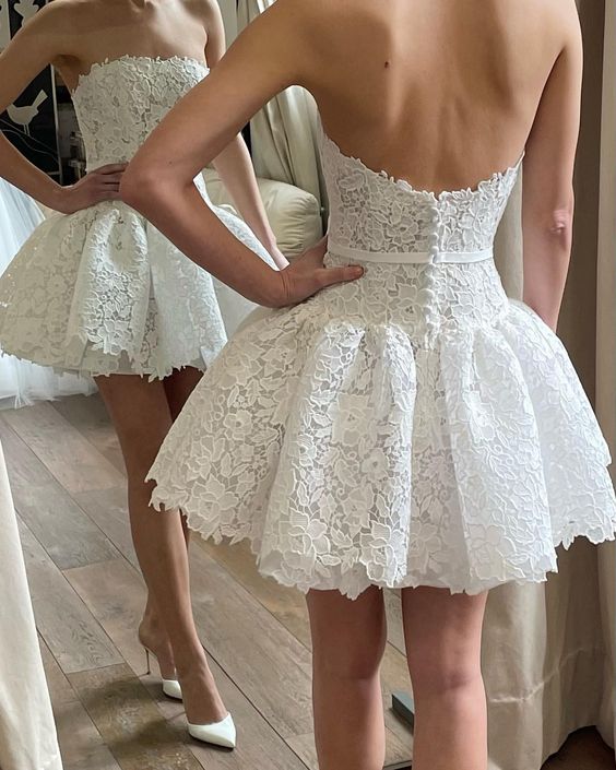Close-up of a bride wearing a white lace V-neck wedding dress, showing bodice details.