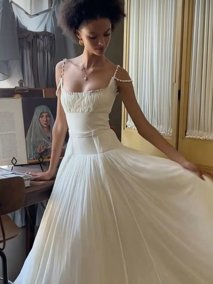 Side view of an elegant A-line V-neck long white wedding dress with a flowing train.