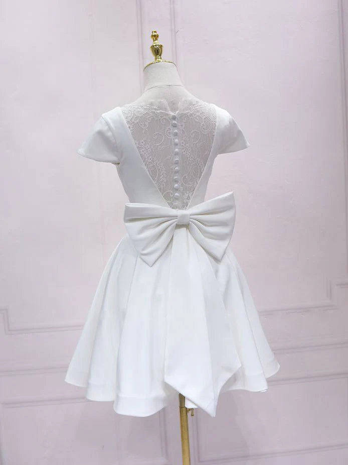 Back view of a woman in a white V-neck satin lace short homecoming dress.