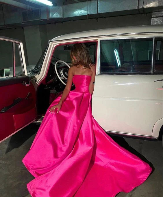 Side view of a woman wearing the pink satin sleeveless prom dress.