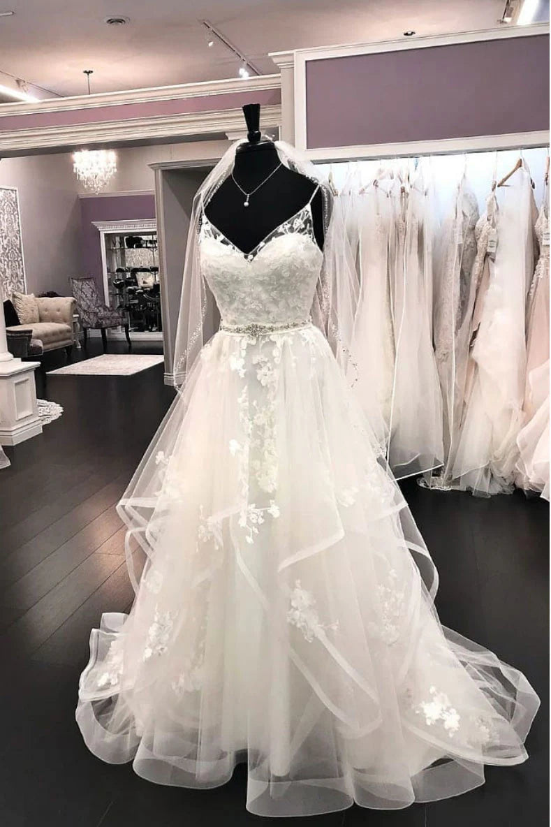 Woman wearing an elegant white tulle lace V-neck long prom or wedding dress.