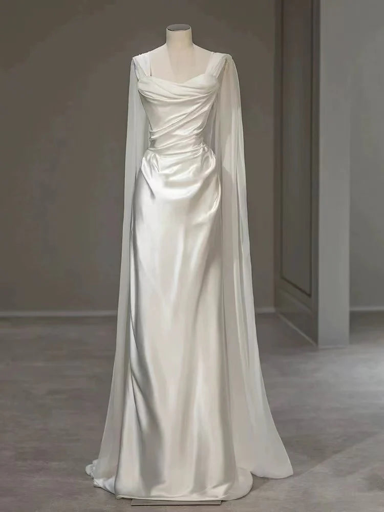 Front view of a white satin A-line wedding dress with V-neck straps and pleats.