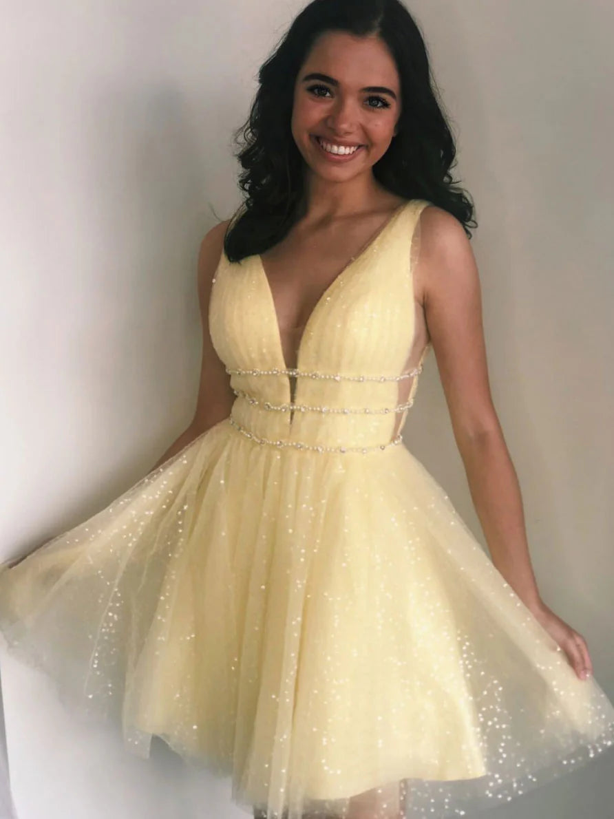 Woman wearing a yellow V-neck short tulle dress with beaded details.