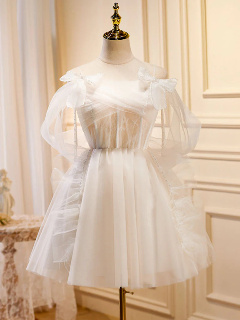 Model wearing a light champagne A-line tulle short prom dress with a V-neck.