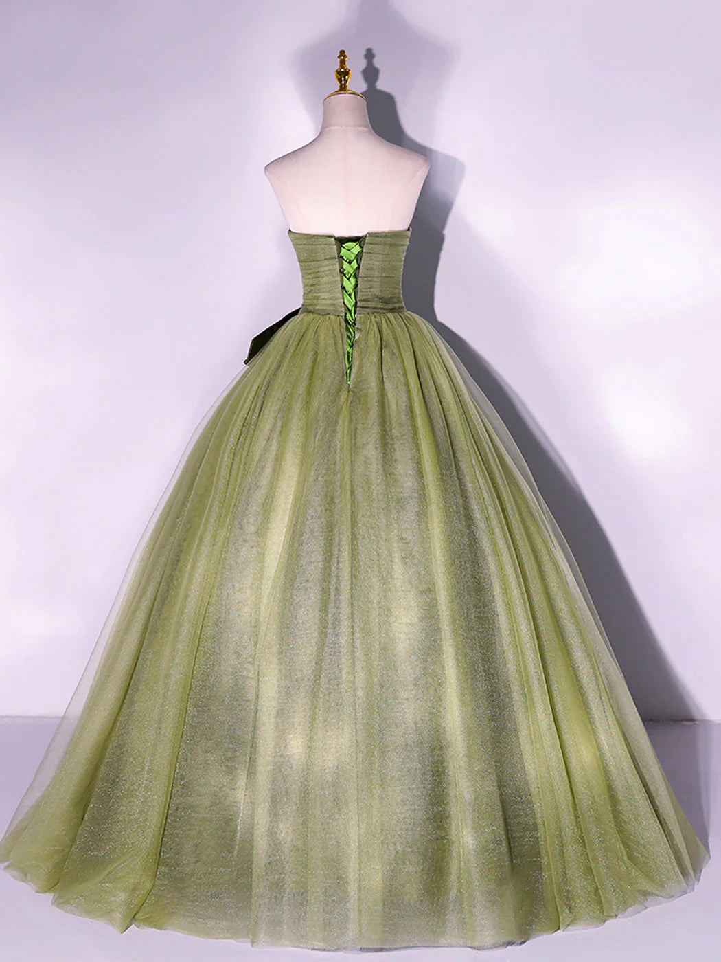 Back view of the green A-line formal dress, showing the delicate tulle fabric.