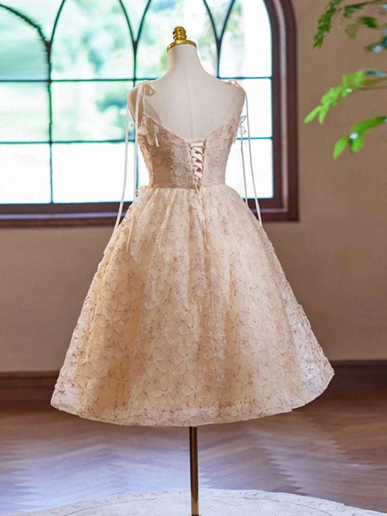 Close-up of the delicate lace and tulle fabric on the champagne short dress.