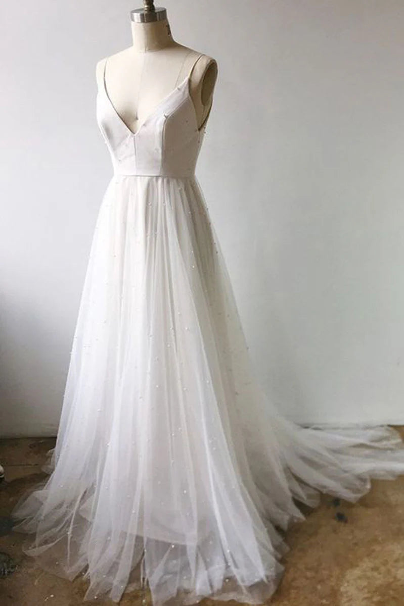 Woman wearing an elegant white V-neck tulle long prom dress with a cinched waist.