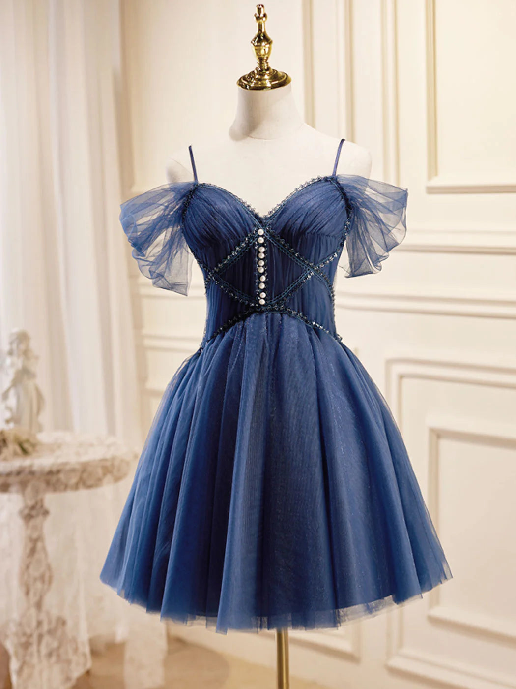 Model wearing a dark blue V-neck tulle short prom dress.