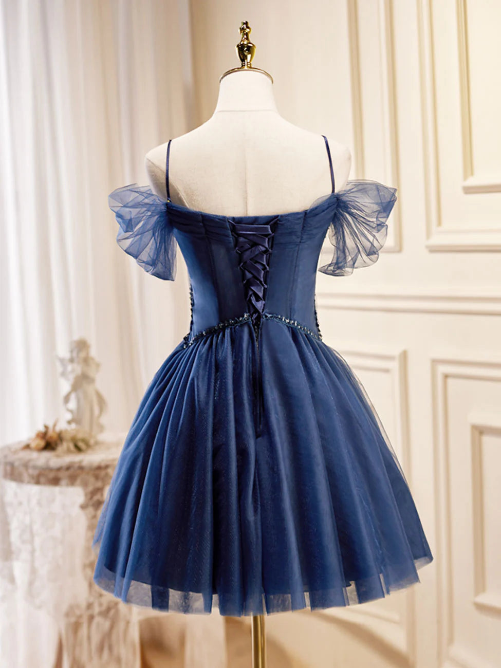 Back view of a dark blue V-neck tulle short prom dress.