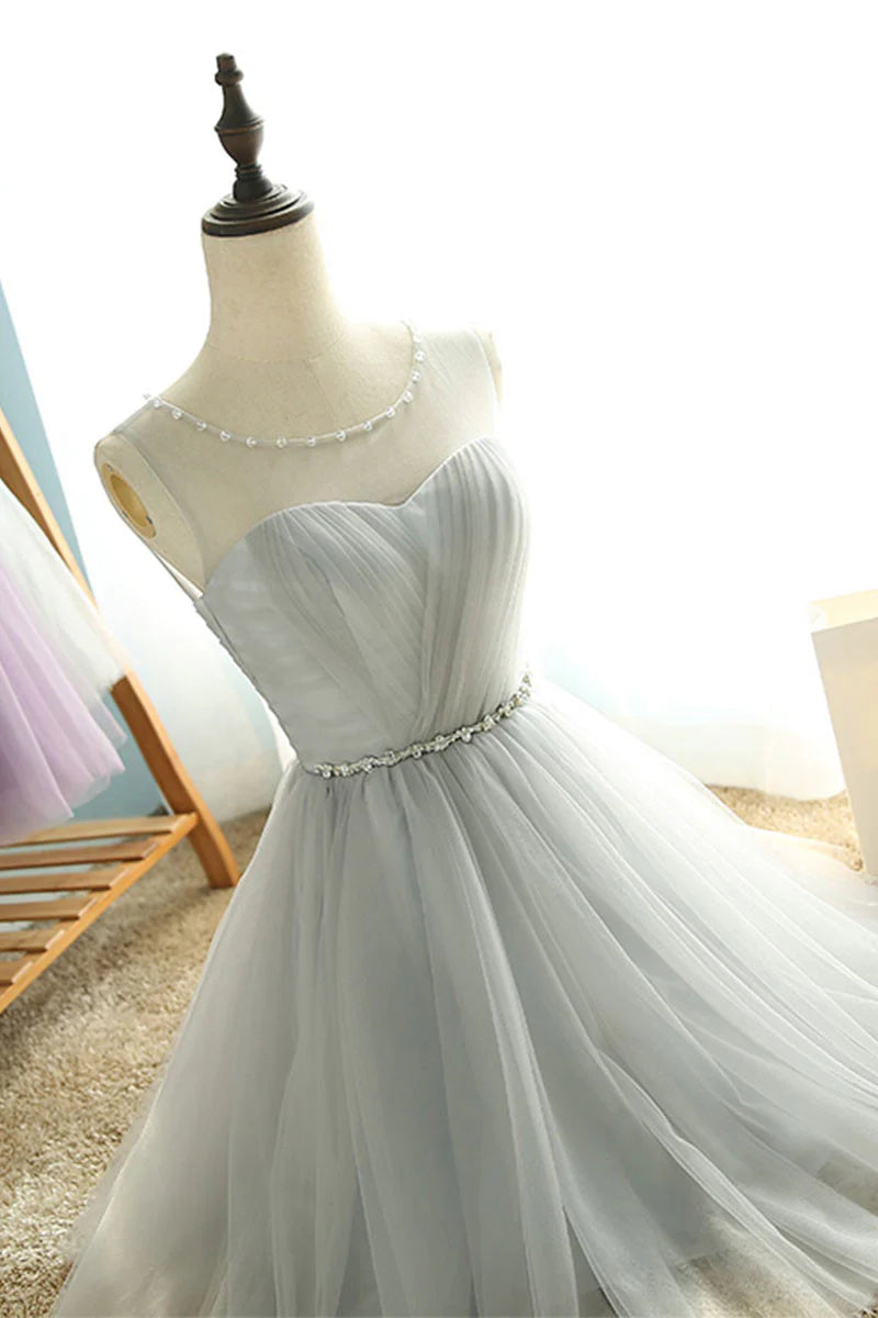 Model wearing a short blush pink A-line tulle dress with a V-neck.