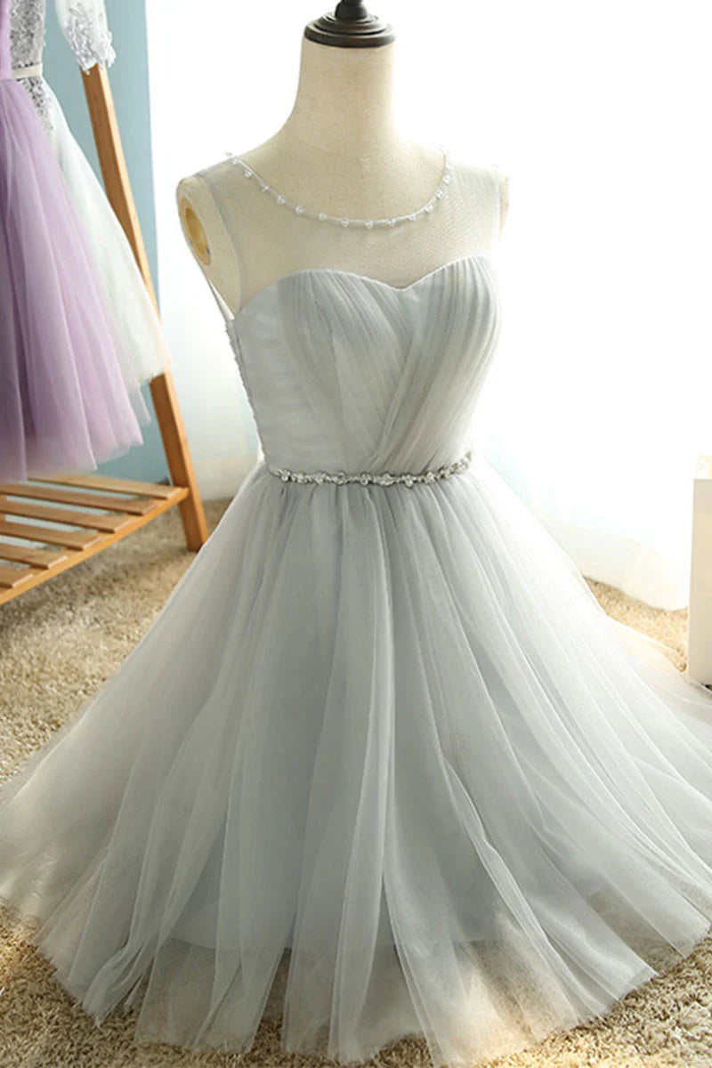 Close-up of the waist and flowing skirt detail of the blush pink tulle dress.