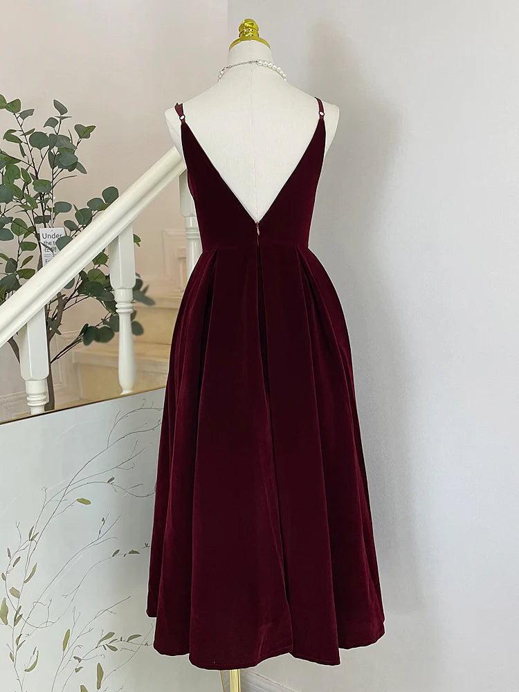 Close-up of burgundy velvet A-line dress fabric and V-neckline.