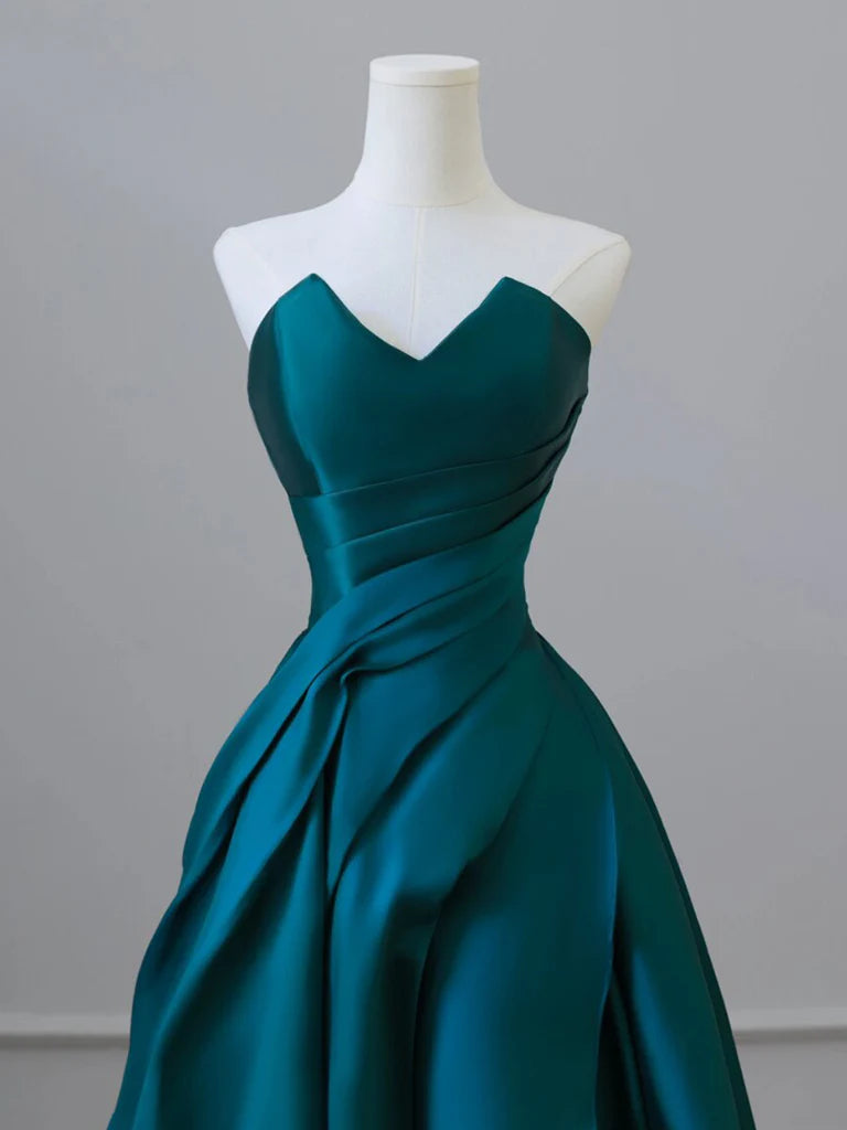 Woman posing in an elegant A-line green satin long prom dress.