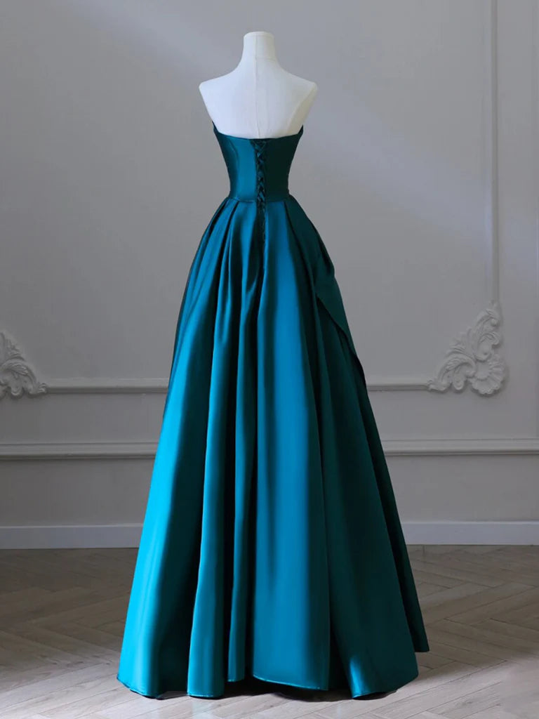 Side view of a woman in a flowing green satin A-line formal dress.