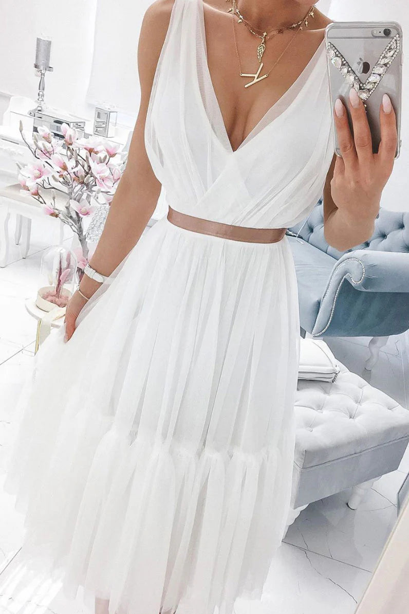 A woman wearing an elegant white V-neck chiffon and tulle prom dress.