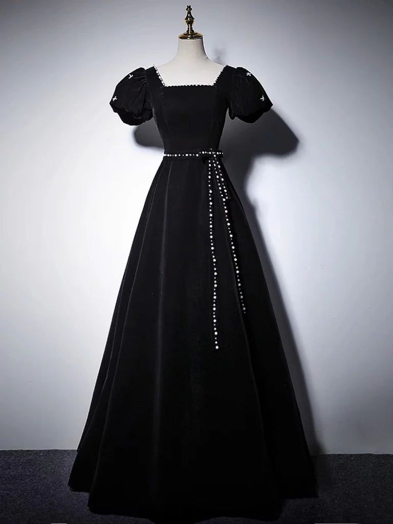 Woman posing in a black A-line velvet long formal dress, front view.