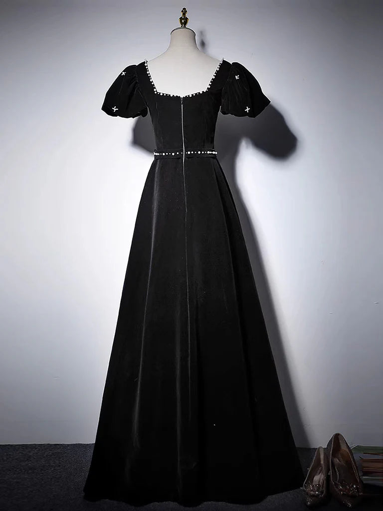 Back view of a woman wearing a black A-line velvet evening gown.
