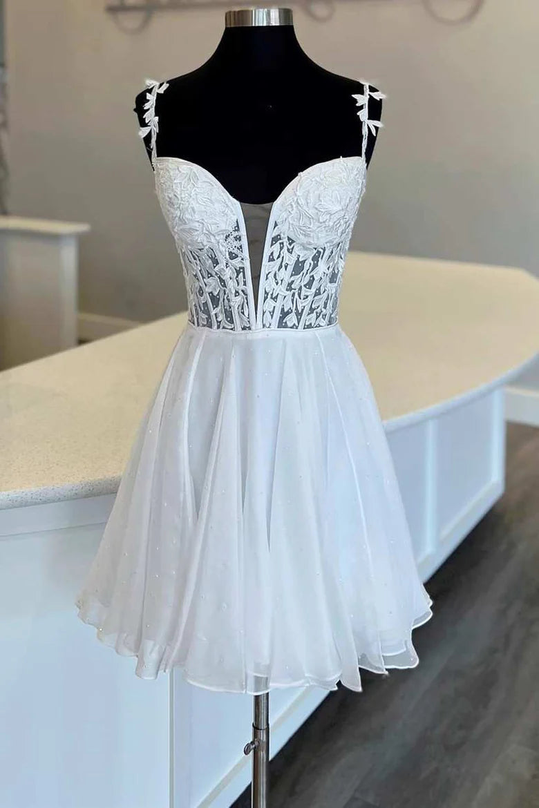 Woman wearing an elegant white A-line homecoming dress with floral appliques and a plunging V-neck.