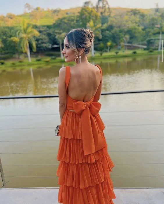 Back view of a sleeveless orange A-line chiffon prom dress.