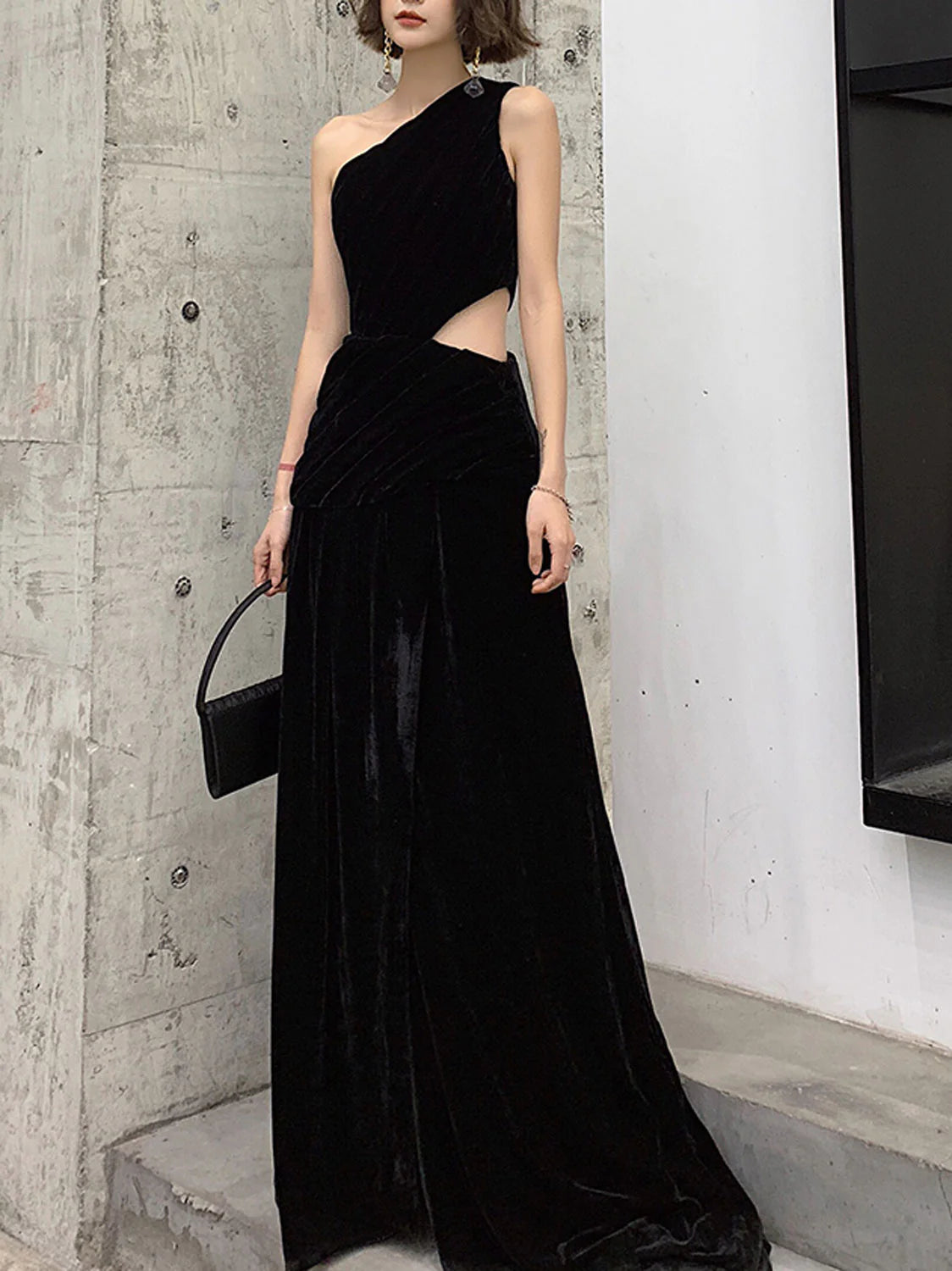 Elegant black velvet one-shoulder long prom dress on a model.
