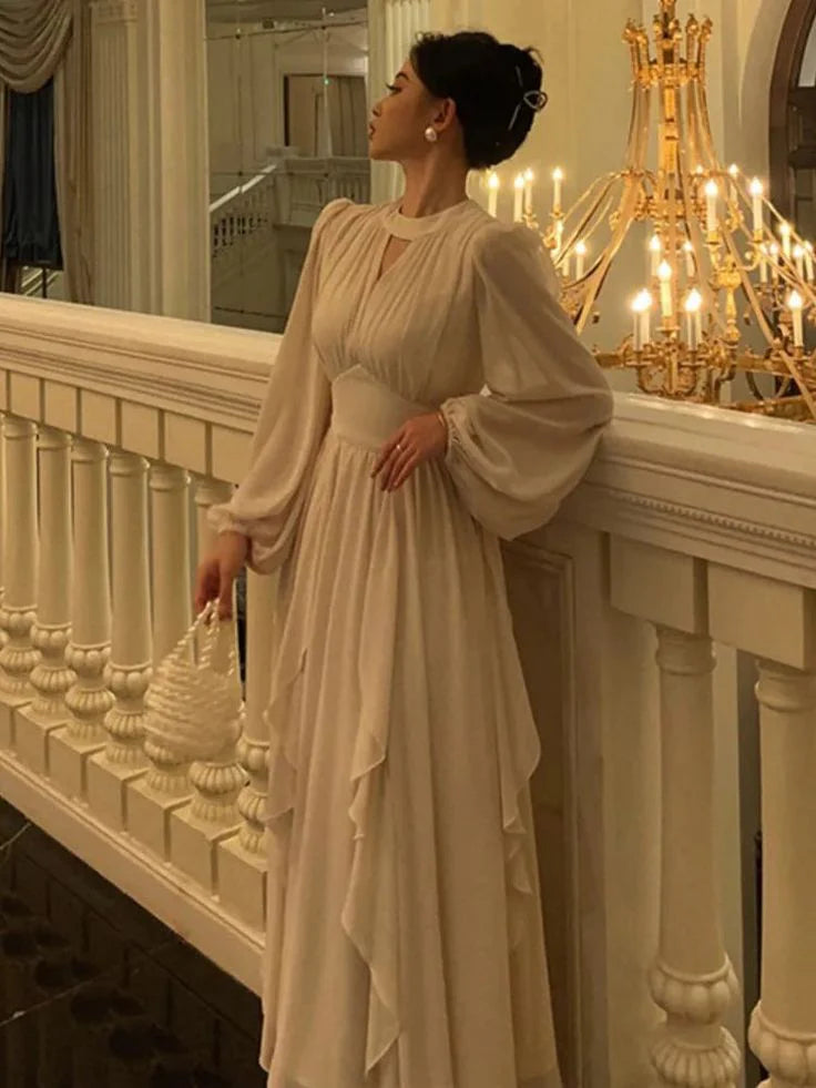 Woman wearing an elegant A-line midi dress with ruffles and lantern sleeves.