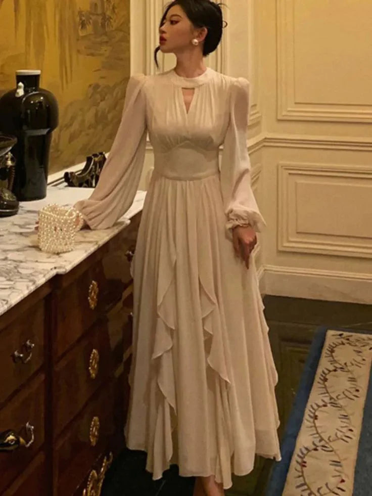 Model posing in a sophisticated ruffled A-line midi dress with lantern sleeves.