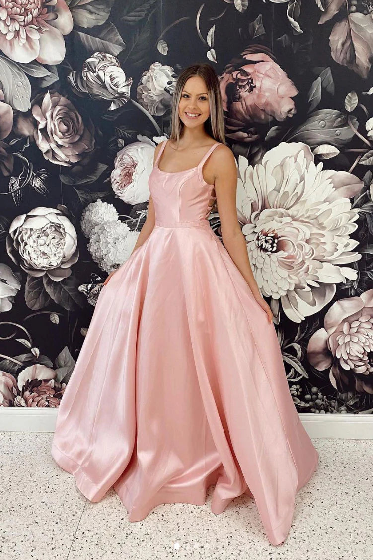 Elegant pink satin spaghetti strap A-line prom dress on a model.