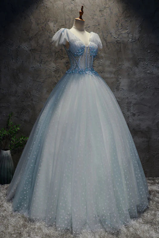 Woman wearing an elegant light blue V-neck tulle long prom dress.