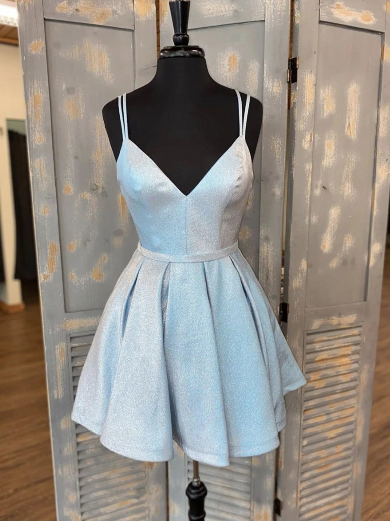 Model wearing a light blue V-neck short A-line prom dress.