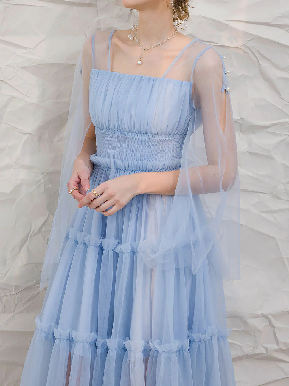Woman wearing an elegant blue tulle tea-length prom dress.