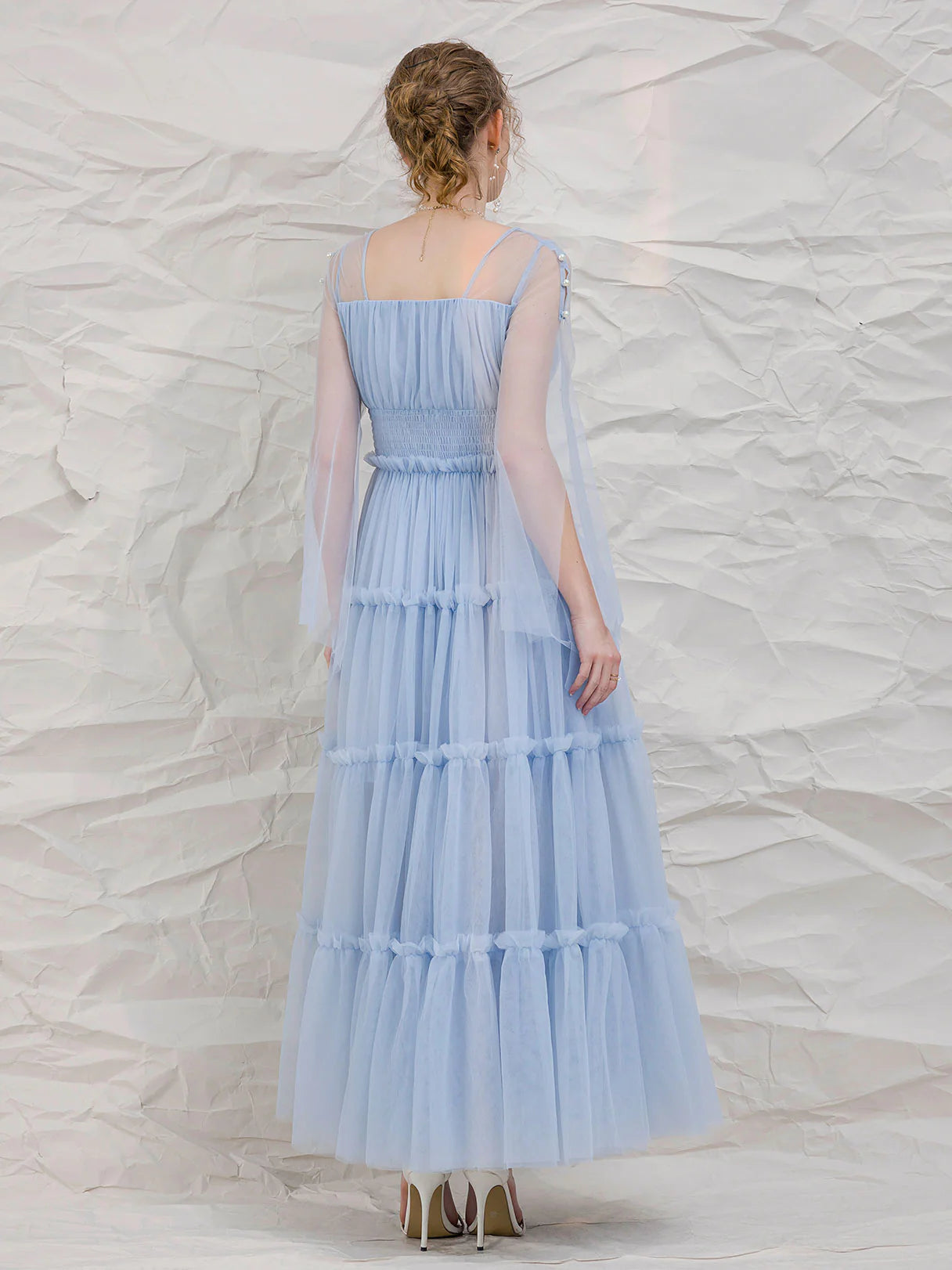 Full view of a woman in a blue tea-length formal evening dress.