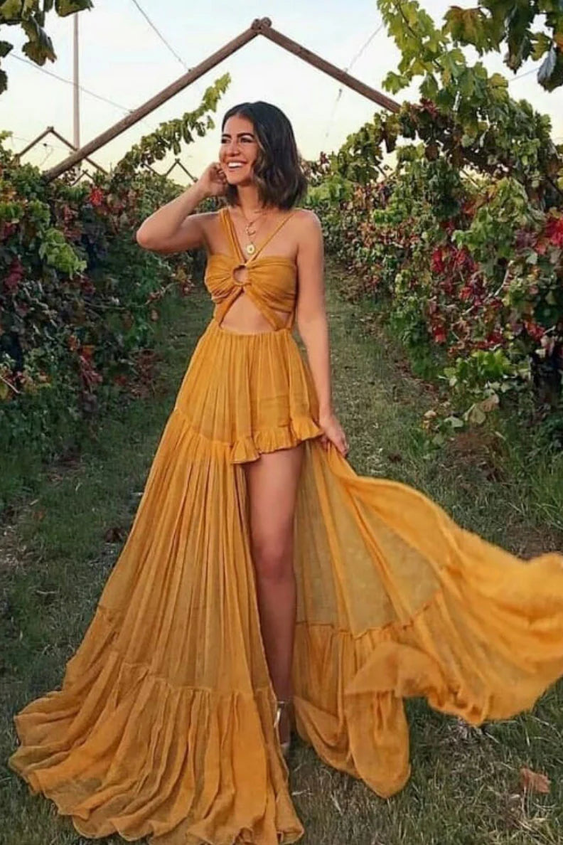 Model wearing an elegant long yellow chiffon prom dress with a unique design.