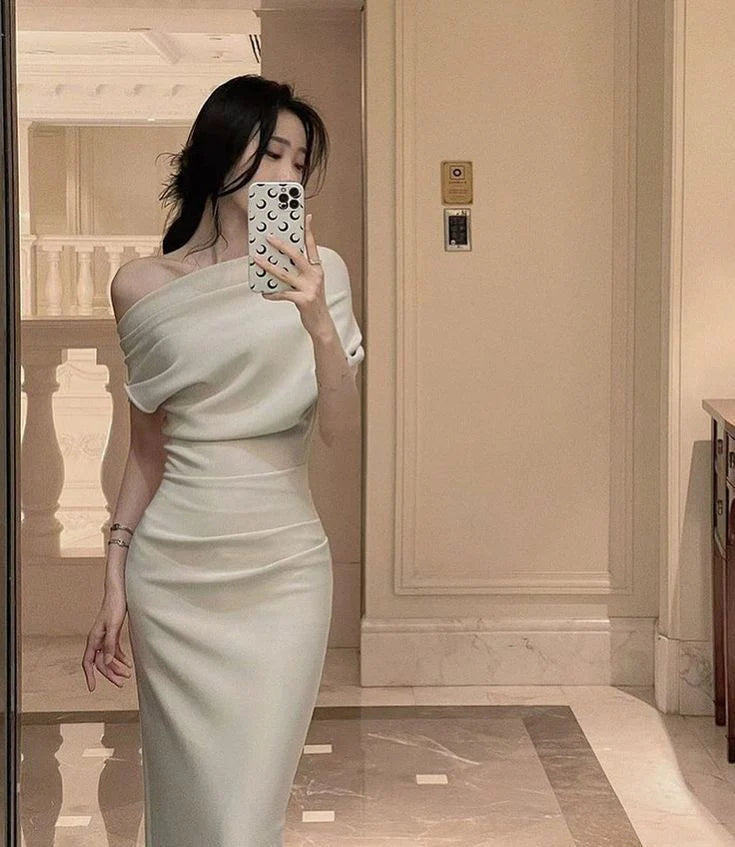 Woman posing in an elegant black asymmetric pleated V-neck maxi evening dress.