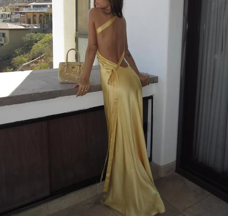 Side profile of a woman wearing a backless satin evening dress.