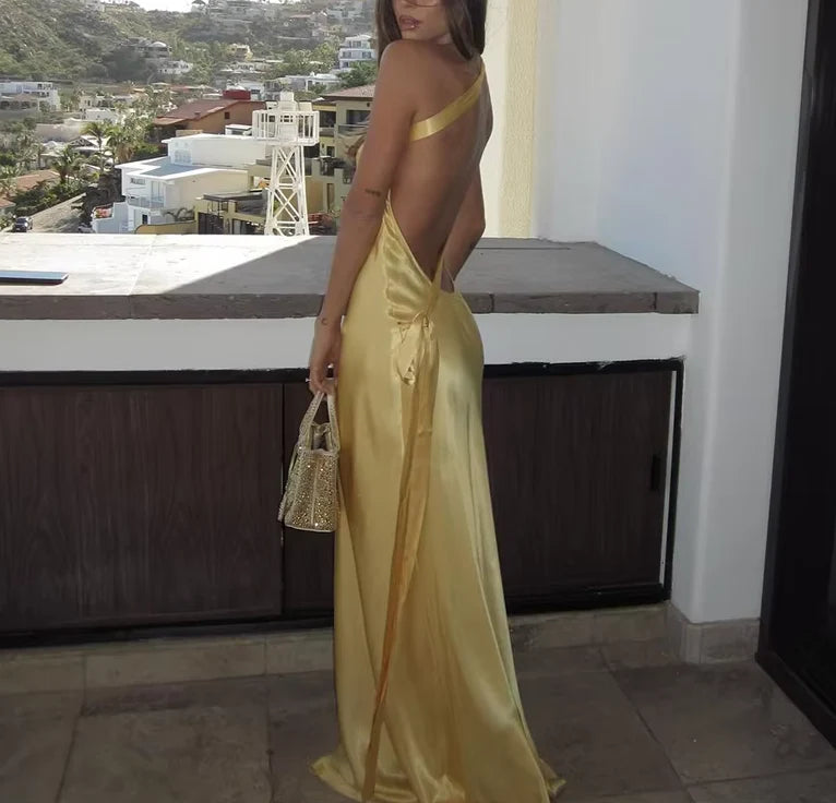 Woman posing gracefully in a luxurious backless satin dress.