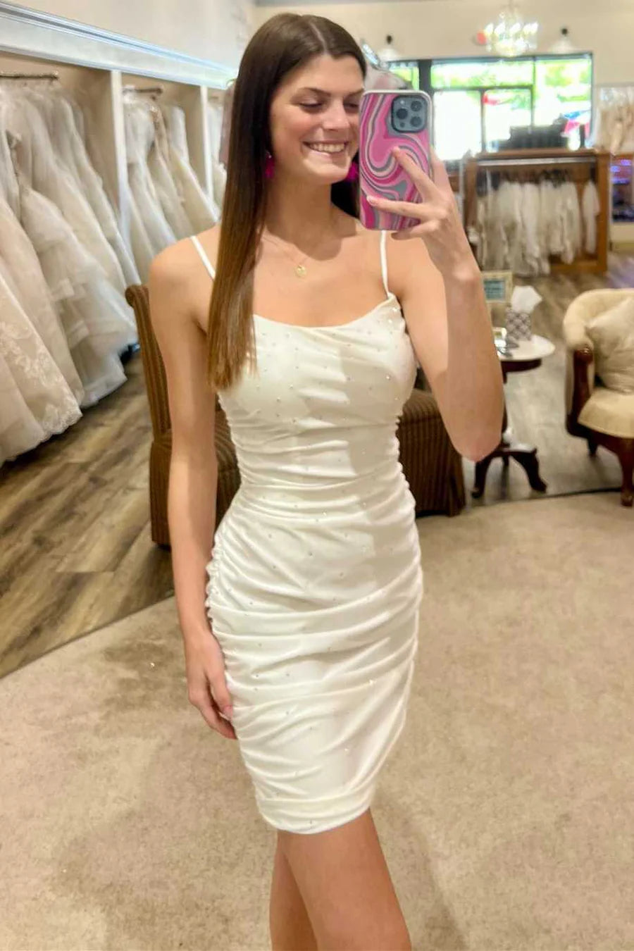Side view of a woman in a white beaded bodycon cocktail dress, highlighting the fitted silhouette.