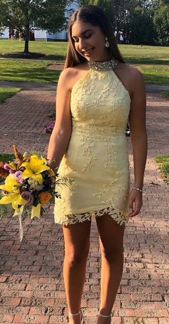Woman wearing a sparkling yellow short beaded bodycon homecoming dress.