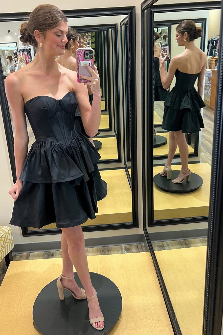 Back view of a black multi-layer A-line strapless short party dress.