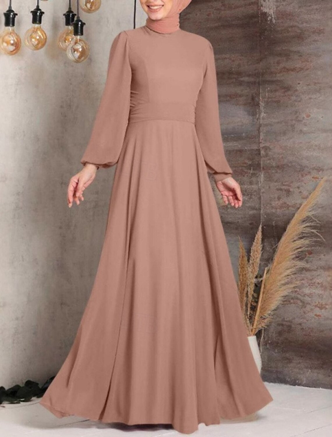 Woman wearing a black long sleeve crew neck swing maxi dress.