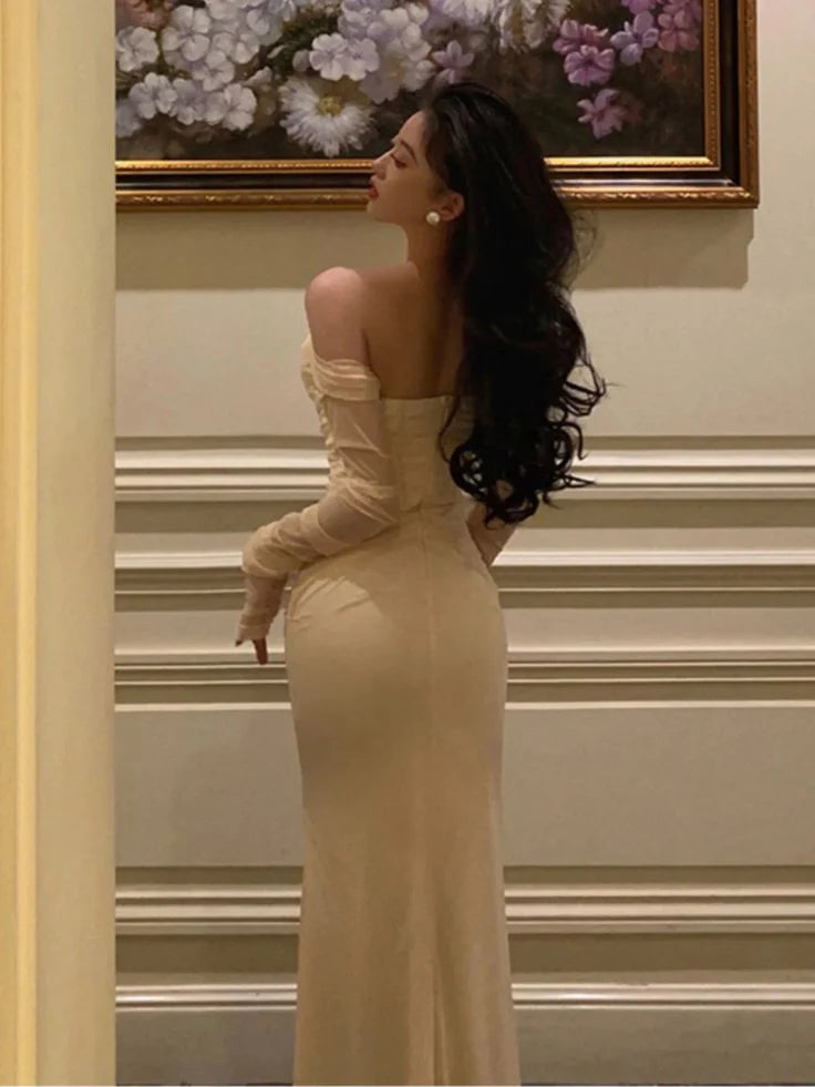 Back view of a woman posing in a black mesh patchwork formal dress.