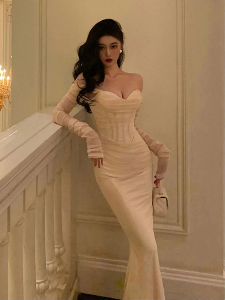 Side profile of a woman wearing a black elegant mesh patchwork gown.