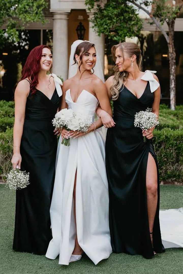 Elegant black satin long bridesmaid dress with V-neck, spaghetti straps, and a bow detail.