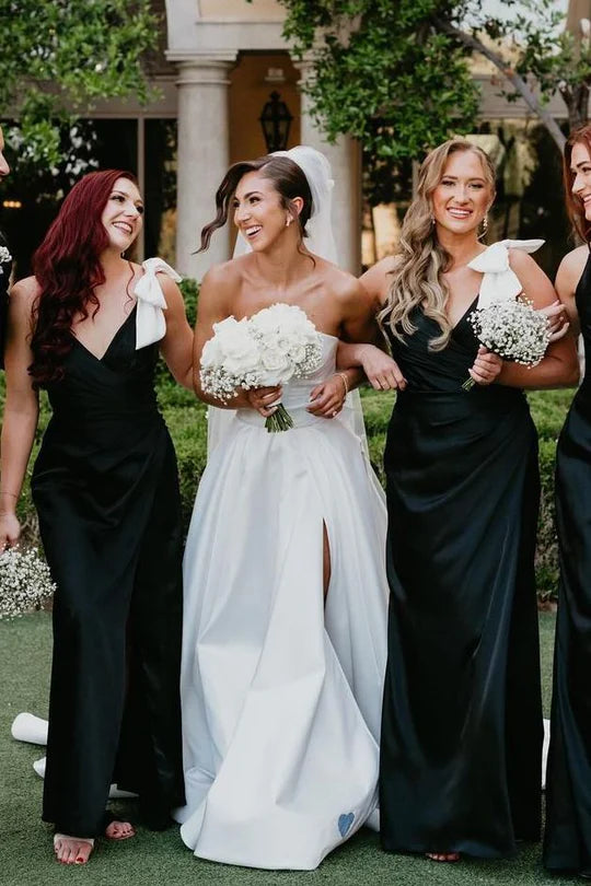 Side view of the black satin bridesmaid dress, highlighting the delicate spaghetti straps and bow.